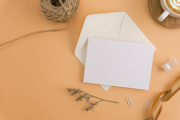 istock A wedding mock up concept. Wedding Invitation, envelopes, cards Papers on light brown background with ribbon and decoration. Top view, flat lay, copy space 973377830