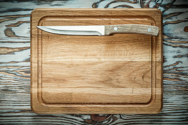 istock Carving board knife on wooden surface 973387780