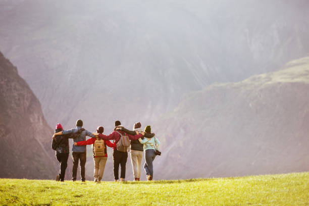 Group friends hugging against mountains valley
