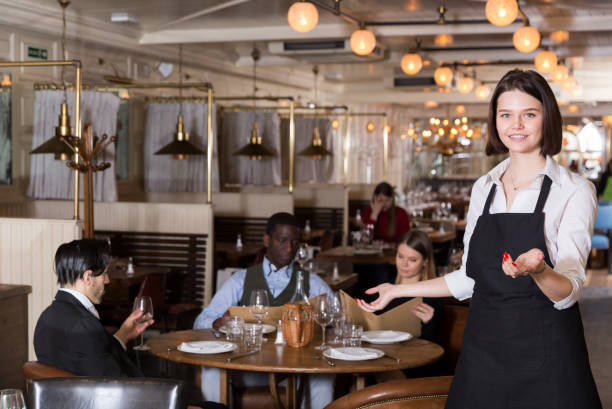istock Waitress meeting customers in restaurant 973407734