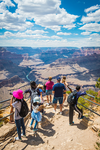 Group of tourists looking over the Grand Canyon and Colorado River far below from Mohave Point on the South Rim, Arizona.