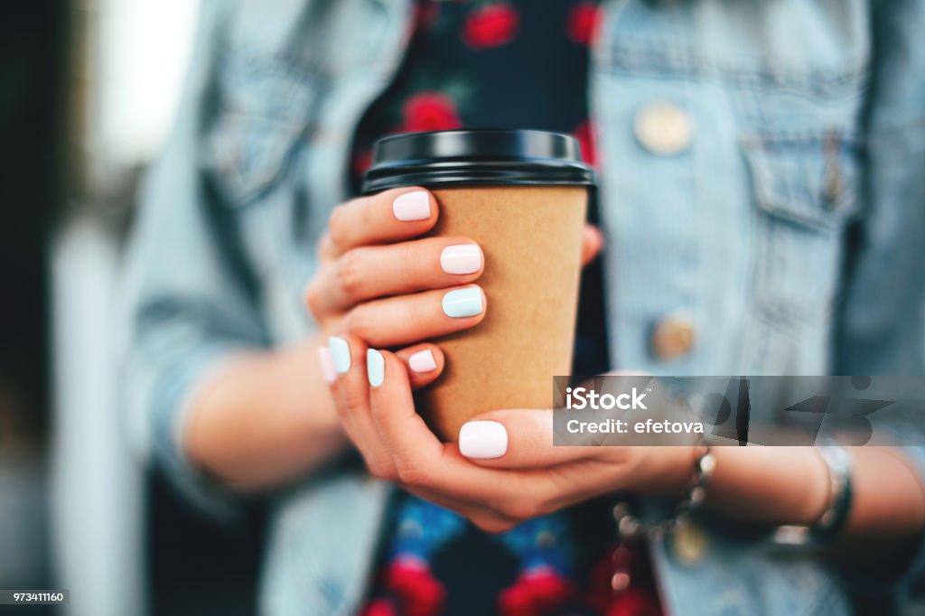 Beautiful fern leaves, macro Female hand with paper cup of coffee take away. Coffee - Drink Stock Photo