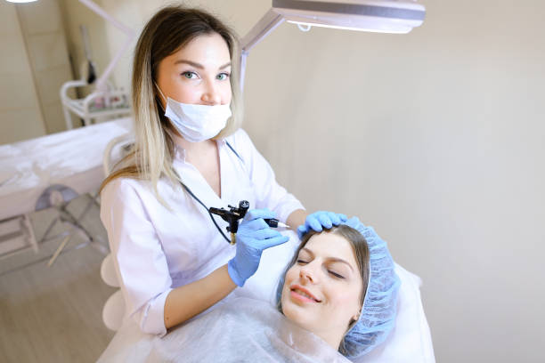istock Charming woman getting qualified permanent makeup procedure by cosmetologist 973412274