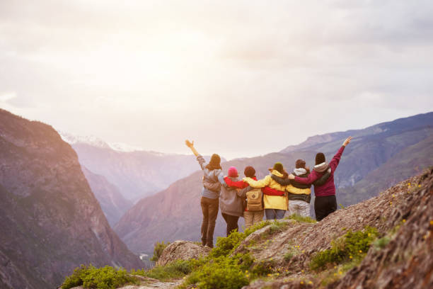 istock Happy friends cliff against mountains 973412310