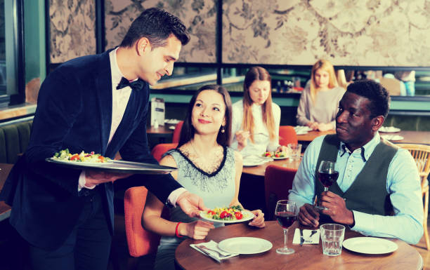 istock Waiter serving couple in restaurant 973415182