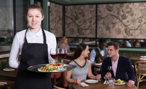 istock Smiling waitress with serving tray 973415198