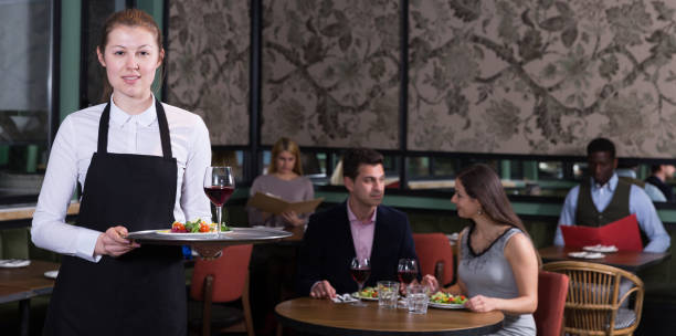 istock Polite waitress holding tray with dishes 973415246