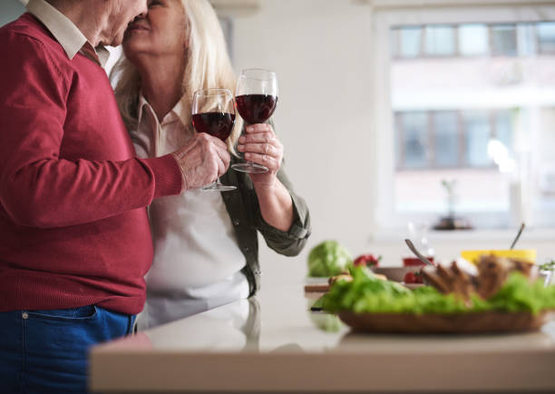 istock Elderly couple celebrating together in kitchen 973427072