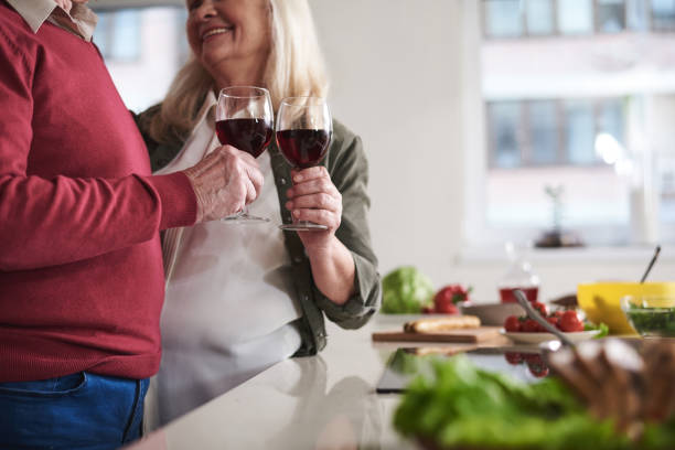 istock Loving old couple celebrating together in kitchen 973427128