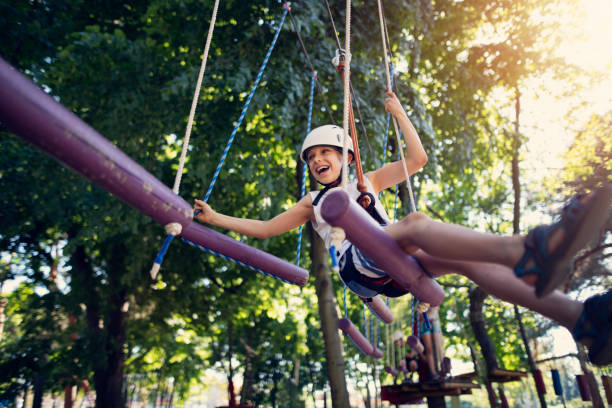 istock Little boy having fun during ropes course in adventure park 973432666