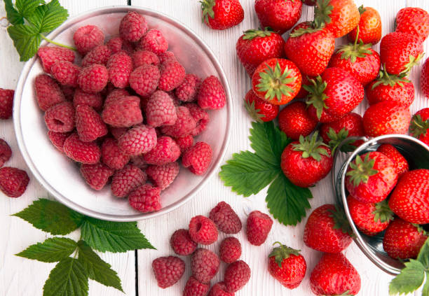 istock Summer healthy fruit composition with red strawberries and raspberries 973438696