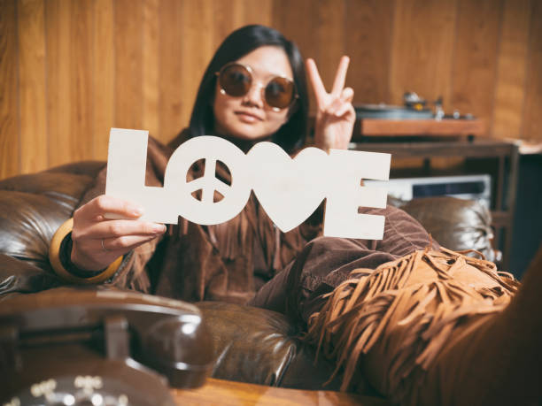 A young Asian woman wearing retro-styled 1970's clothing. Both the model and set are styled to portray a teenager/young adult from 1976 with period correct clothing, furniture, and props.
