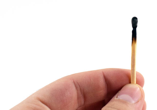 istock man's hand holding a used match 973445786