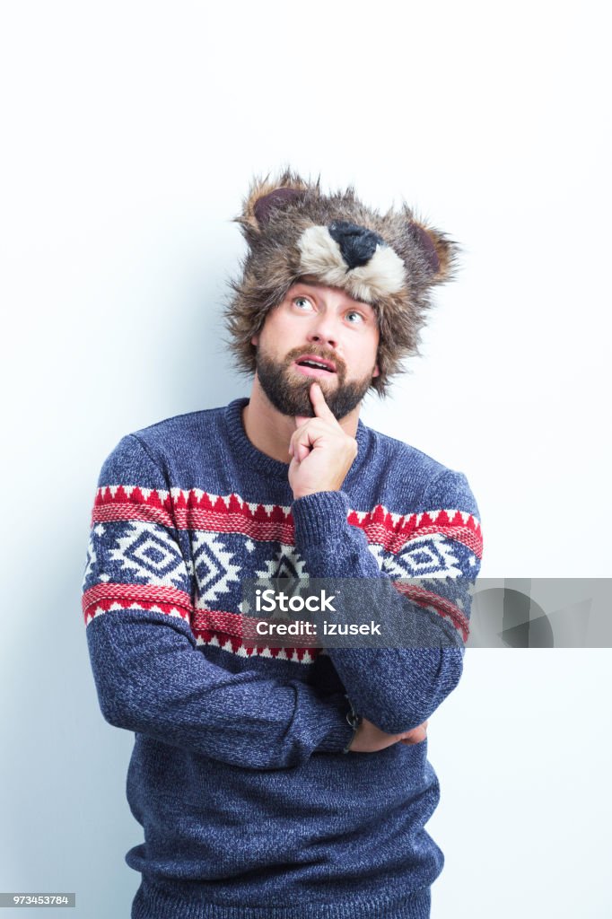 Thoughtful man in warm clothing Portrait of young man in winter wear looking away and thinking against white background Fashion Model Stock Photo