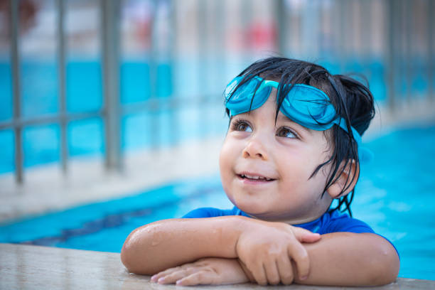 istock Happy boy enjoying summer time in swimming pool 973456990