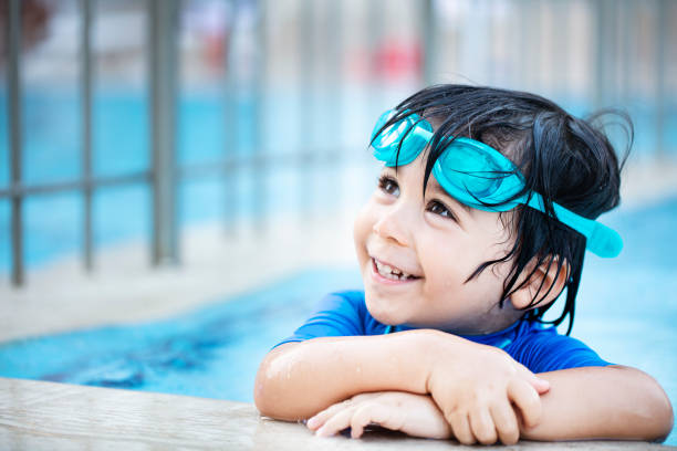 szczęśliwy chłopak cieszący się letnim czasem w basenie - swimming child swimming pool indoors zdjęcia i obrazy z banku zdjęć