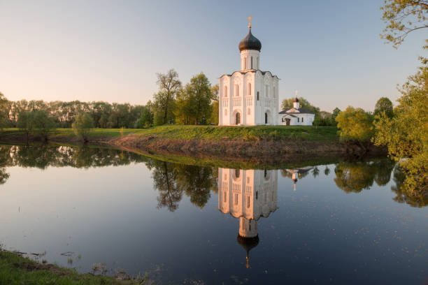 Church of Intercession on the Nerl in the evening, at sunset Church of Intercession of Holy Virgin on Nerl River, Bogolyubovo, Russia. Ancient white-stone temple with reflection in the water vladimir russia stock pictures, royalty-free photos & images