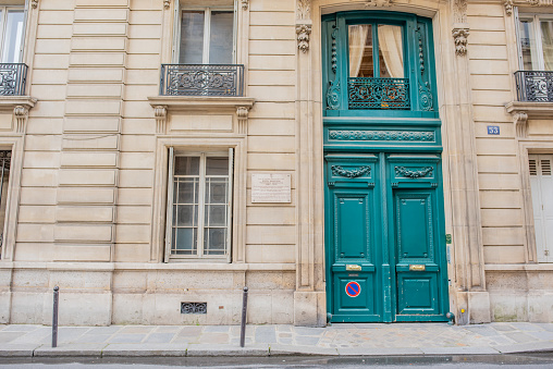 Paris \\ France - May 15, 2018: A beautiful door with traditional French detail on a building where Edith Wharton lived, on the famous Rue de Varenne, site of embassies and other government buildings.