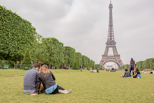 Paris, France - November 14, 2013: People walk in front of the Eiffel Tower on the Champ de Mars in Paris, France.
