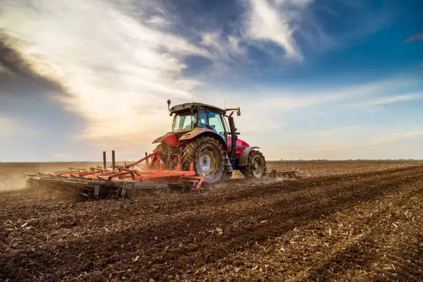 Tractor cultivating field at spring