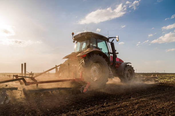 istock Tractor cultivating field at spring 973481366