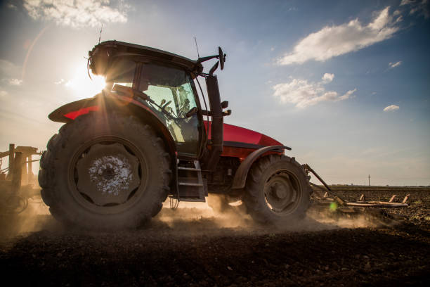 istock Tractor cultivating field at spring 973481570