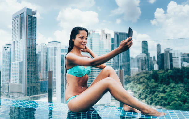 istock Young woman taking a selfie by the pool 973482140