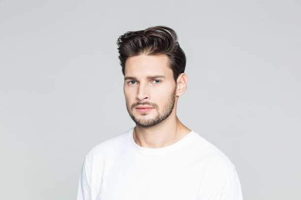 istock Serious young man on grey background 973484426