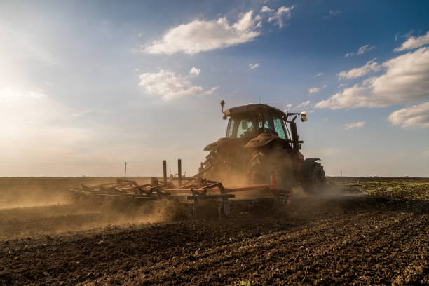 istock Tractor cultivating field at spring 973484778