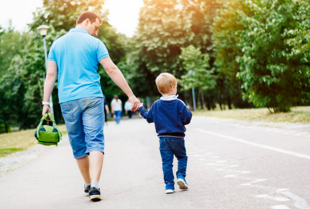 istock Father and son walking in the park after school 973500996