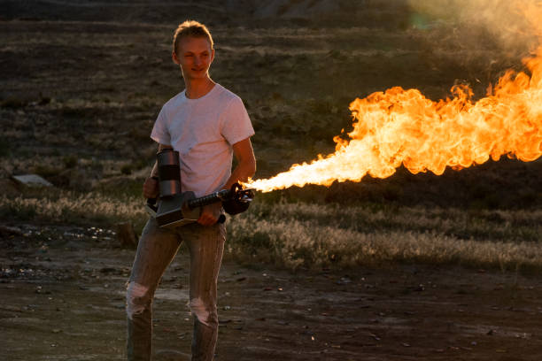 young man operating a flamethrower - flamethrower imagens e fotografias de stock