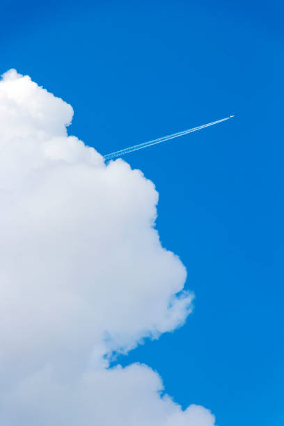 istock Skyscape with a plane, contrail and a cloud 973511414