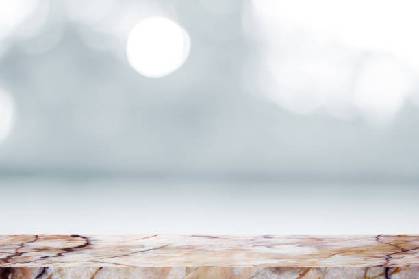 istock Empty marble table with backdrop white blurred nature background, Can be used for display your product 973512696