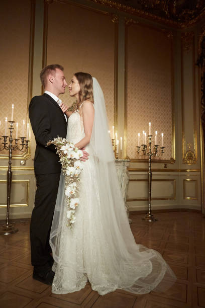 Wedding couple in a luxurious interior in the Baroque style is hugging each other. Beautiful model girl in white dress. Man in suit. Beauty bride with groom. Female and male portrait. Woman with lace veil. Lady and guy indoor boda de la pareja en un lujoso interior en estilo barroco es abrazándose unos a otros. chica hermosa modelo en vestido blanco. hombre con traje. novia con novio en belleza. retrato femenino y masculino. mujer con velo de encaje. dama y hombre interior.