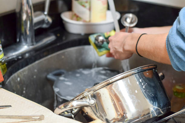 istock Closeup on woman's hands washing dirty dishes 973522364