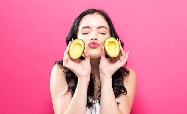 istock Young woman holding an avocado 973534090
