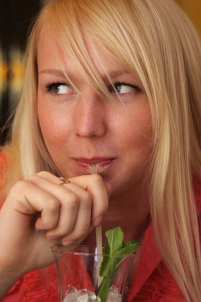 Smiling blond girl drinking closeup stock photo
