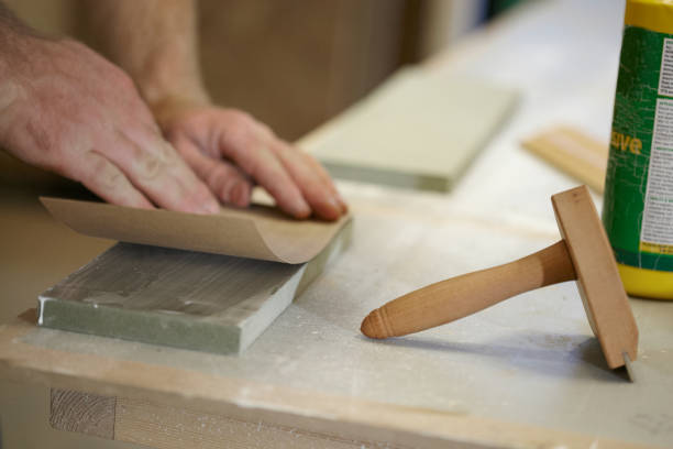istock Carpenter Adding A Veneer To Wood 973579502