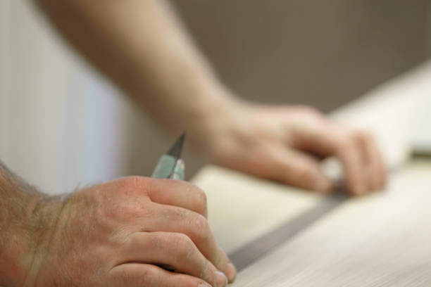 istock Carpenter Adding A Veneer To Wood 973579538