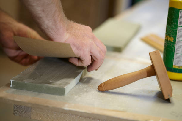 istock Carpenter Adding A Veneer To Wood 973579598