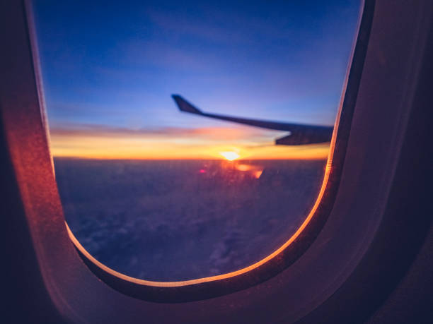istock above clouds with aircraft wing at sunset 973579888