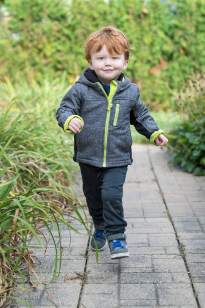 istock Happy Cute Baby Boy Running on Sidewalk 973596416