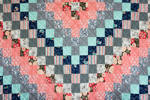 Salmon orange/pink and blue squares in large quilt