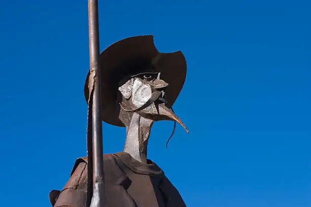 Photo of Metal Quixote statue against a clear blue sky