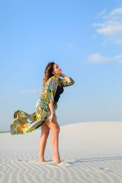 istock Young charming woman wearing green beach robe standing on white 973631994