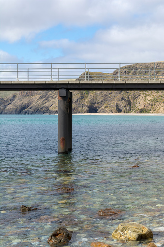 Rapid Bay, South Australia, Australia - May 5, 2018: New cement jetty with the coastal hills, cave in the background and the vast calm  ocean in the foreground. Part of the Fleurieu Peninsula.