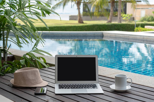 istock laptop and hat at the pool. 973643718
