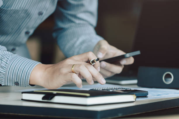 istock Man holding pen and calculate and making note at office. 973646706