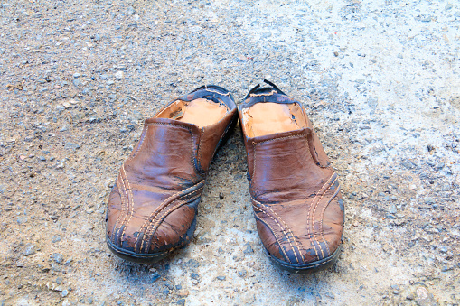 old shoes leather worn out On floor road background