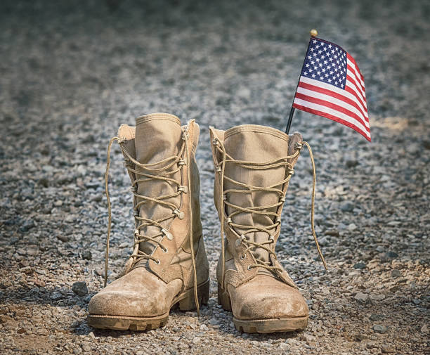 istock Old military combat boots with the American flag 973664684